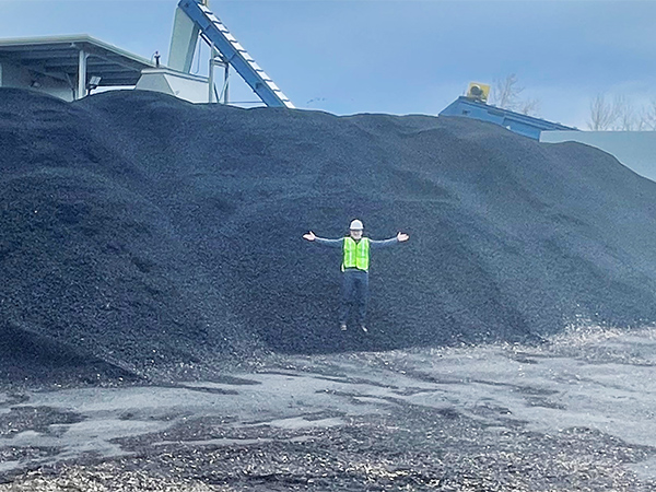 Matt Krumenauer, V.P. for Special Projects, in a pile of biochar